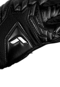 Schwarze Handschuhe mit strukturierten Mustern, ausgestattet mit einem glatten Lederpatch und weißem Logo. Hergestellt aus robustem synthetischem Material, konzipiert für besseren Halt.