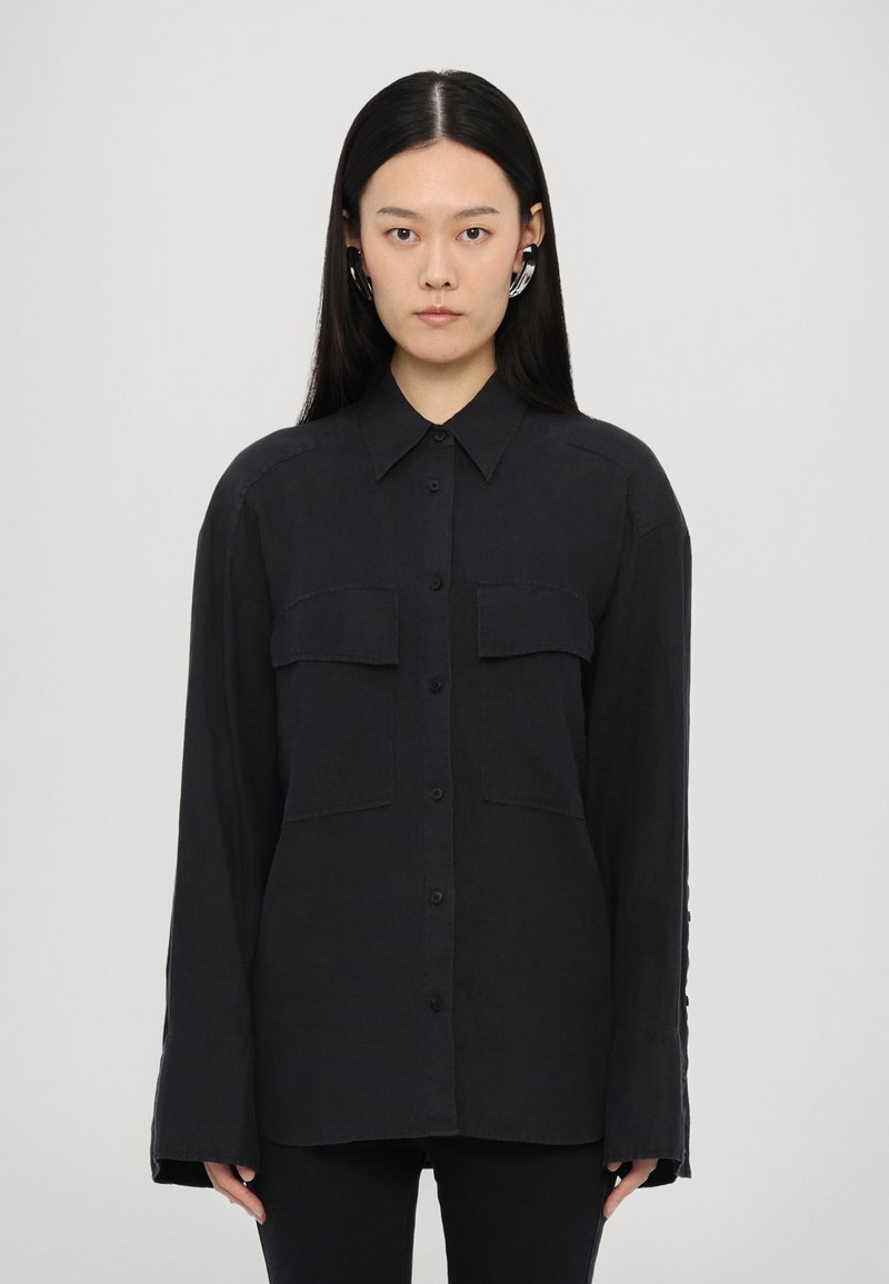 Black long-sleeve shirt made of lightweight fabric, featuring a button-down front, two chest pockets, and a relaxed fit with a plain texture.