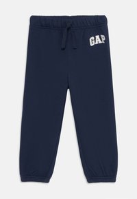 Marinblåa sweatpants med elastisk midja, snörning och elastiska avslut. Har broderad "GAP"-logga på framsidan. Mjuk tyg.