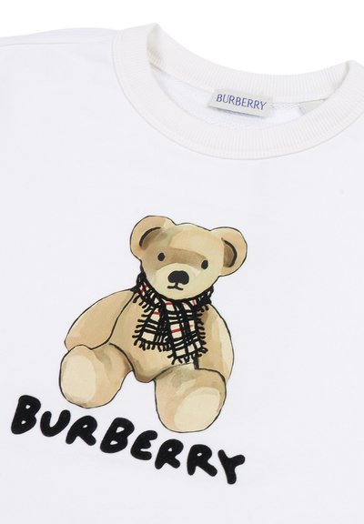 Felpa bianca con una stampa di un orsetto di peluche marrone che indossa una sciarpa a scacchi bianca e nera, con la scritta "BURBERRY" in nero sotto.
