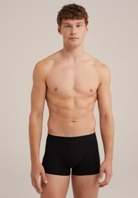 Črne bokserice iz bombaža z gladko teksturo in prilegajočim dizajnom. Imajo enobarvno površino, elastičen pas in sprednji žep.