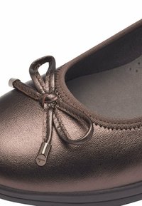 Bronze metallische Ballerinas mit runder Zehenform und einem dekorativen Schleifendetail. Glatte Oberfläche mit subtilen Nähten entlang der Kante.