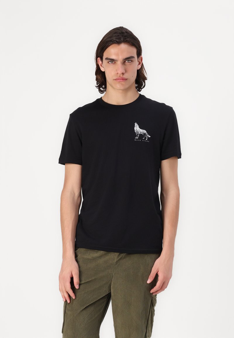 Zwarte katoenen T-shirt met een witte grafiek van een wolf op de linkerborst. Korte mouwen en een ronde halslijn. Eenvoudig, aansluitend ontwerp.