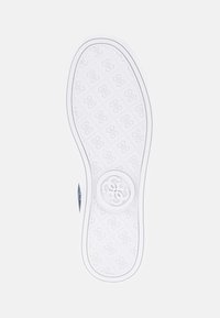 Vit gummiskosula med ett strukturerat mönster av upprepade geometriska design och en central logotyp. Kanterna är rundade och släta.