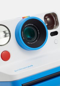 Polaroid camera with a white body, blue lens mount, and red button. Features a round lens, autofocus, and labeled for i-Type film.