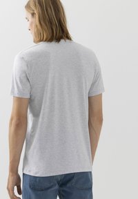 T-shirt grigio a maniche corte realizzato in tessuto morbido. Design classico con scollo rotondo, texture liscia e vestibilità comoda. Senza schemi o accenti visibili.