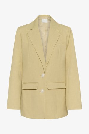 Bēšas krāsas sieviešu žakete ar iegriezuma atlokiem, divām priekšējām kabatām ar vāciņu, vienu krūškurvja kabatu, diviem baltiem pogām un gariem piedurknēm.