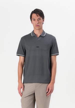 Polo shirt gris foncé avec un motif texturé, doté d'un col à revers et d'accents blancs sur le col et les manches. Logo sur la poitrine.
