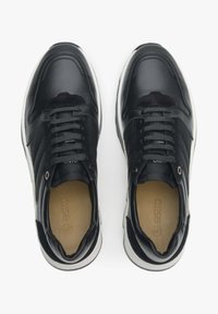 Czarne skórzane sneakersy z klasycznym wiązaniem, białą gumową podeszwą, gładką fakturą i subtelnymi akcentami po bokach.