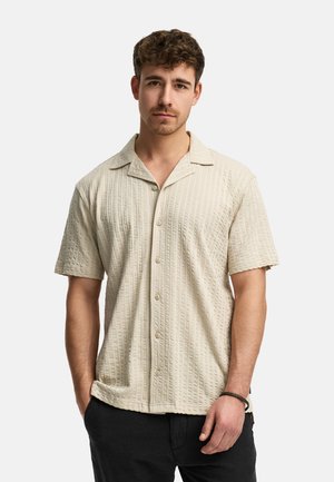 Short-sleeve, button-up shirt in light beige with a textured pattern and a laid-back collar. Made from breathable fabric, features a relaxed fit.