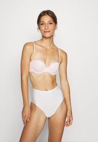 Sutiã rosa claro com aro e alças ajustáveis, combinado com cuecas brancas de cintura alta. Tecido suave, design simples, sem padrões ou detalhes.