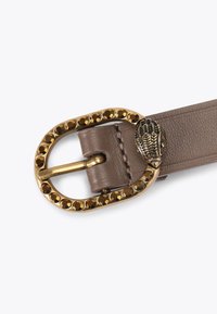 Cintura in finta pelle marrone con fibbia ovale dorata decorata con strass marroni e un dettagliato accento a forma di foglia.