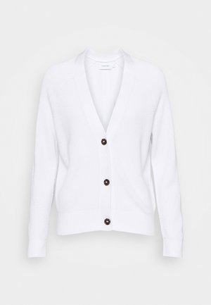 Cardigan blanc en tricot avec manches longues, col en V, et trois boutons foncés sur le devant, présenté sur un fond neutre.