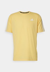 Camiseta de algodón amarilla con mangas cortas, que presenta el logo blanco de Adidas en el pecho y tres rayas blancas en los hombros.