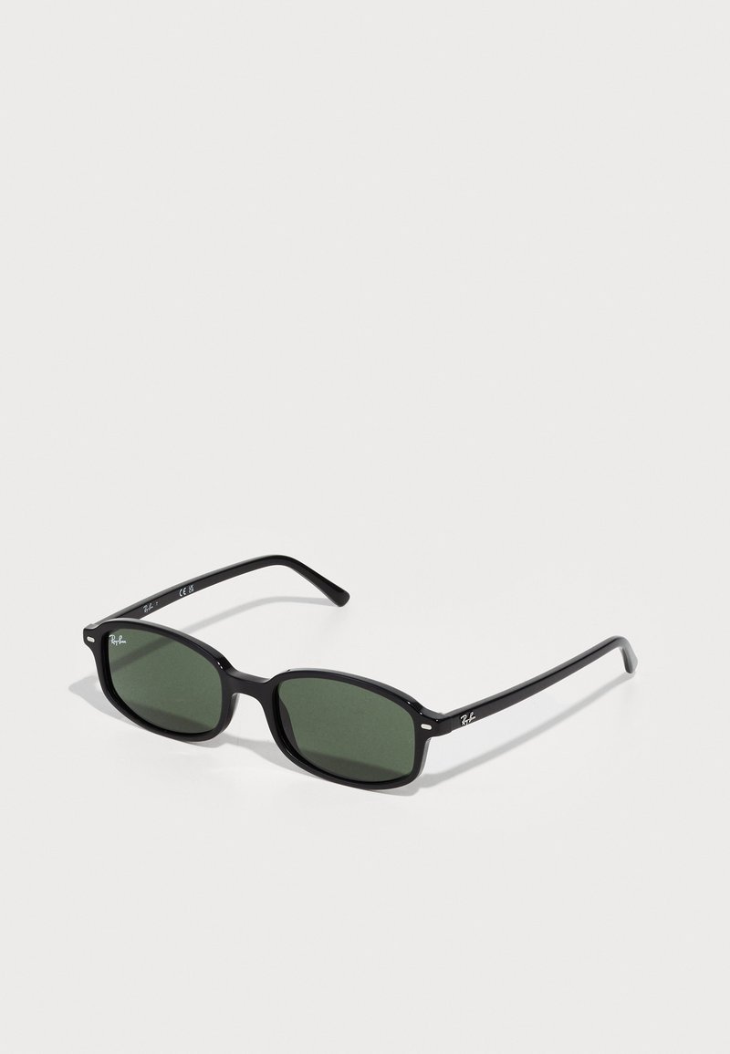 Gafas de sol rectangulares negras con lentes verde oscuro, que presentan un puente mate y sutiles acentos de logo en las varillas.