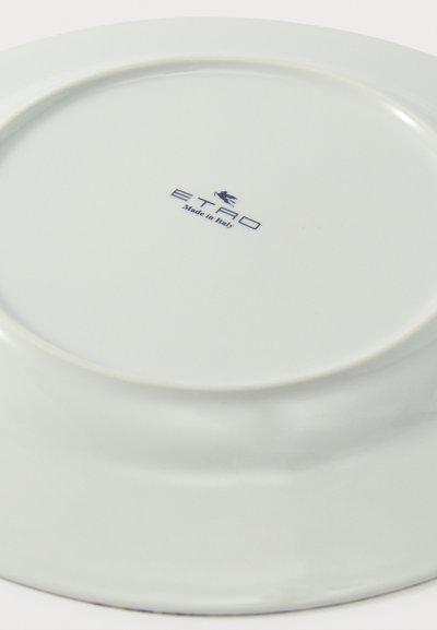 Assiette ronde en céramique blanche retournée avec le logo "ETRO Made in Italy" imprimé en bleu au centre.
