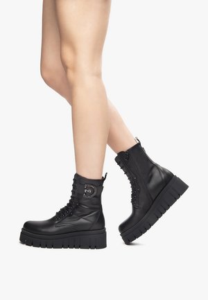 Black leather combat boots with a chunky sole, lace-up front, side zipper, and a chain-accented logo detail on the ankle.