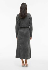 Grijs geribbelde gebreide jurk met een cropped top en een lange rok. Gestructureerde stof, lange mouwen, aansluitende taille en een enkel-lange zoom.