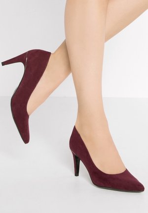 Zamszowe buty na wysokim obcasie w kolorze bordo, z wąskim noskiem i cienkim obcasem typu szpilka, charakteryzujące się gładką teksturą i eleganckim designem.