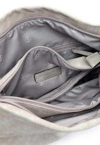 Sac en tissu gris clair à texture lisse, doté de plusieurs compartiments, d'une fermeture éclair et d'une doublure intérieure à motifs.