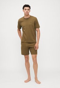 Khaki színű pamut póló és rövidnadrág szett, texturált felülettel, kerek nyakkivágással, rövid ujjal, és egy diszkrét márkalogóval a pólón.