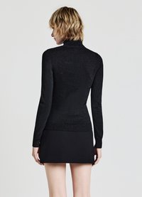 Schwarzer langärmeliger Rollkragenpullover mit glitzernder Textur. Verfügt über gerippte Bündchen und Saum, taillierte Passform, getragen mit einem schwarzen Minirock.