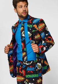 Colorful suit featuring comic book-style graphics in red, yellow, and blue on a black background. Includes a vibrant blue shirt and purple lining.