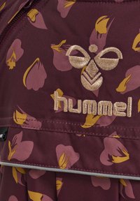 Bordeaux stof met gele en roze bloemenprint. Voorzien van een geborduurd "hummel" logo in goud en decoratieve ritsdetails.