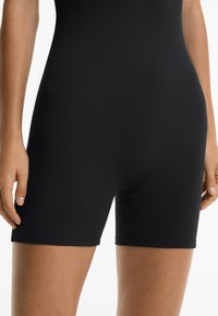 Zwarte fietsshorts gemaakt van een soepel, rekbaar materiaal. Kenmerken zijn een aansluitend ontwerp, een lengte tot halverwege de dij en subtiele stiksels aan de zoom.