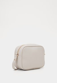 Malá, obdélníková taška z texturovaného světle šedého materiálu se zlatým zipem. Obsahuje odnímatelný popruh pro různorodé nošení.