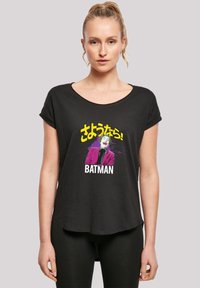 Juodas trumpas rankovės marškinėliai su Jokerio grafika purpuru kostiumu ir japonišku tekstu, kuriame ryškiu baltu šriftu parašyta "BATMAN".