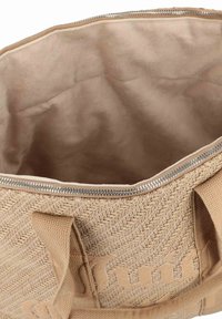 Gran bolsa tote de color beige tejido, con cierre de cremallera, forro interior suave y exterior texturizado contrastante con un patrón de espiga.