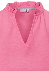Roze blouse van een TEXTUURSTOF, met een gerimpelde halslijn en een V-vormige uitsnijding. Etiket geeft "Nümph" aan, maat 36.