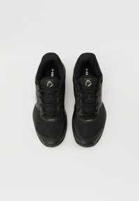 Schwarze Sportschuhe mit einem Obermaterial aus Netzgewebe, strukturierten Oberflächen, gepolstertem Schaft und Schnürverschluss. Mit einem reflektierenden Logo an der Seite.