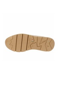 Suola della scarpa in materiale gommoso beige, con un motivo a zigzag e la scritta "Nero Giardini Made in Italy". Superficie texturizzata.