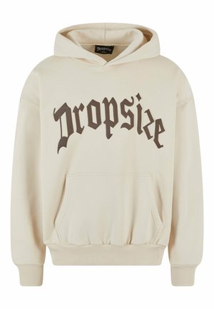 Hoodie crème en tissu doux avec une poche avant, des poignets côtelés et un grand logo "Dropsize" marron foncé sur la poitrine.