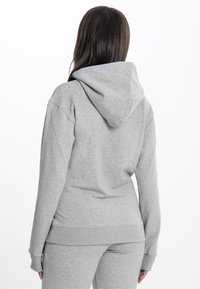 Felpa grigia con cappuccio, in misto cotone, texture morbida, maniche e fondo a costine, caratterizzata da una vestibilità classica e tasca a marsupio.