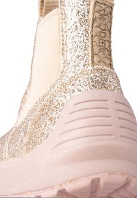 Stövlar med en glittrig guldöverdel, matt rosa sula, texturerad sidopanel och elastiska detaljer. Perfekta för vardagligt bruk.