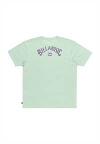 Mintgroene t-shirt met kort mouw en een ontspannen pasvorm, met een opvallend paarse "Billabong" logo en golvende grafiek op de achterkant.