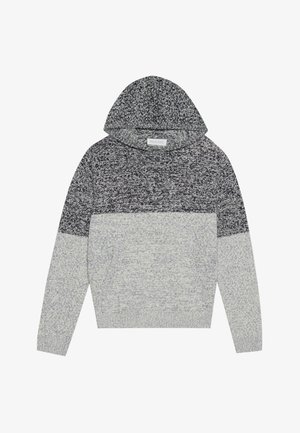 Pulovers mīkstajā pelēkā un melnā adījumā ar vieglu tekstūru, kuram ir plašs kakls, garas piedurknes un regulējama kapuce.