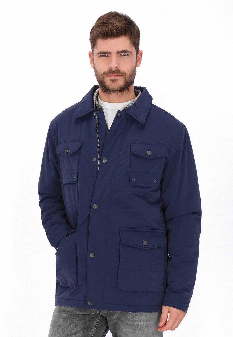 Chaqueta azul marino hecha de material duradero, con cuello, varios bolsillos frontales y cierres de botones a presión. Textura suave, diseño práctico.