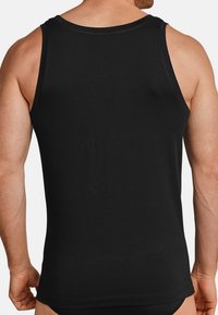 Sort tanktop lavet af glat bomuld, med racerback-design og lige søm. Stoffet virker blødt med minimale sømme.