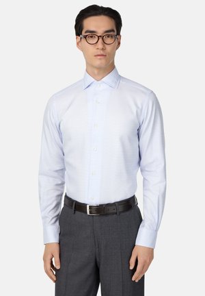 Lichtblauw geblokt overhemd met een puntkraag en lange mouwen, gedragen met een donkergrijze broek en een bruine leren riem.