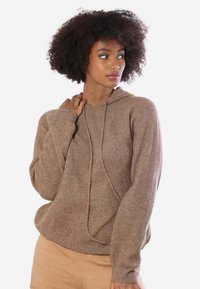 Felpa a coste marrone con cappuccio e lacci, dotata di maniche lunghe e vestibilità ampia. Il materiale sembra morbido con leggere variazioni di texture.