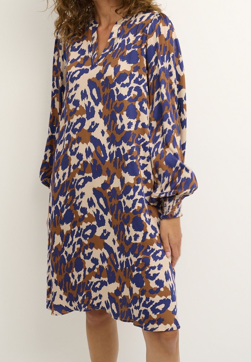 Abito con stampa leopardata in marrone, blu e crema; tessuto leggero; maniche lunghe con polsini arricciati; scollo a V.