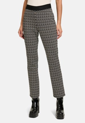Schwarze gemusterte Hosen mit breitem Bund und taillierter Passform, die ein geometrisches Design in weißen und beigen Tönen aufweisen.
