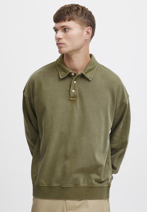Oliven grønn, langermet polo-sweater med krage, tre-knaps placket og ribbestrikkede mansjetter. Relaxed fit med teksturert stoff.