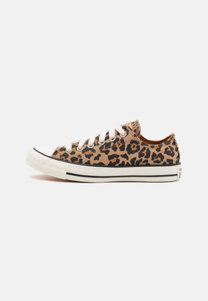 Leopard print canvas sneakers with white laces, rubber toe cap, and black sole stripe. Low-top design with contrasting interior color.