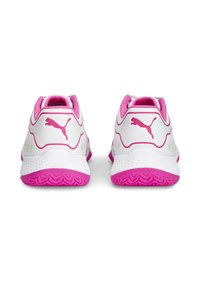 Zapatillas deportivas blancas con acentos en rosa, presentando una suela de goma texturizada, parte superior sintética suave y logo lateral. Diseño ligero y talón acolchado.