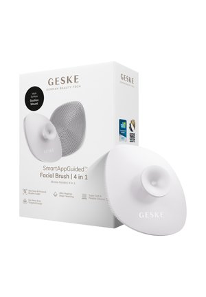 Brosse faciale 4-en-1 GESKE SmartAppGuided avec support ventouse multi-surface, poils en silicone et badges de récompense sur l'emballage.